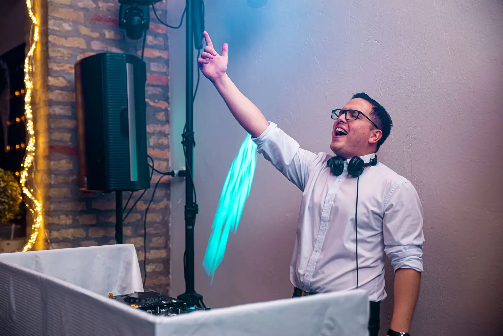 A DJ magasba emelt kézzel vezényli a tánctér közönségét
